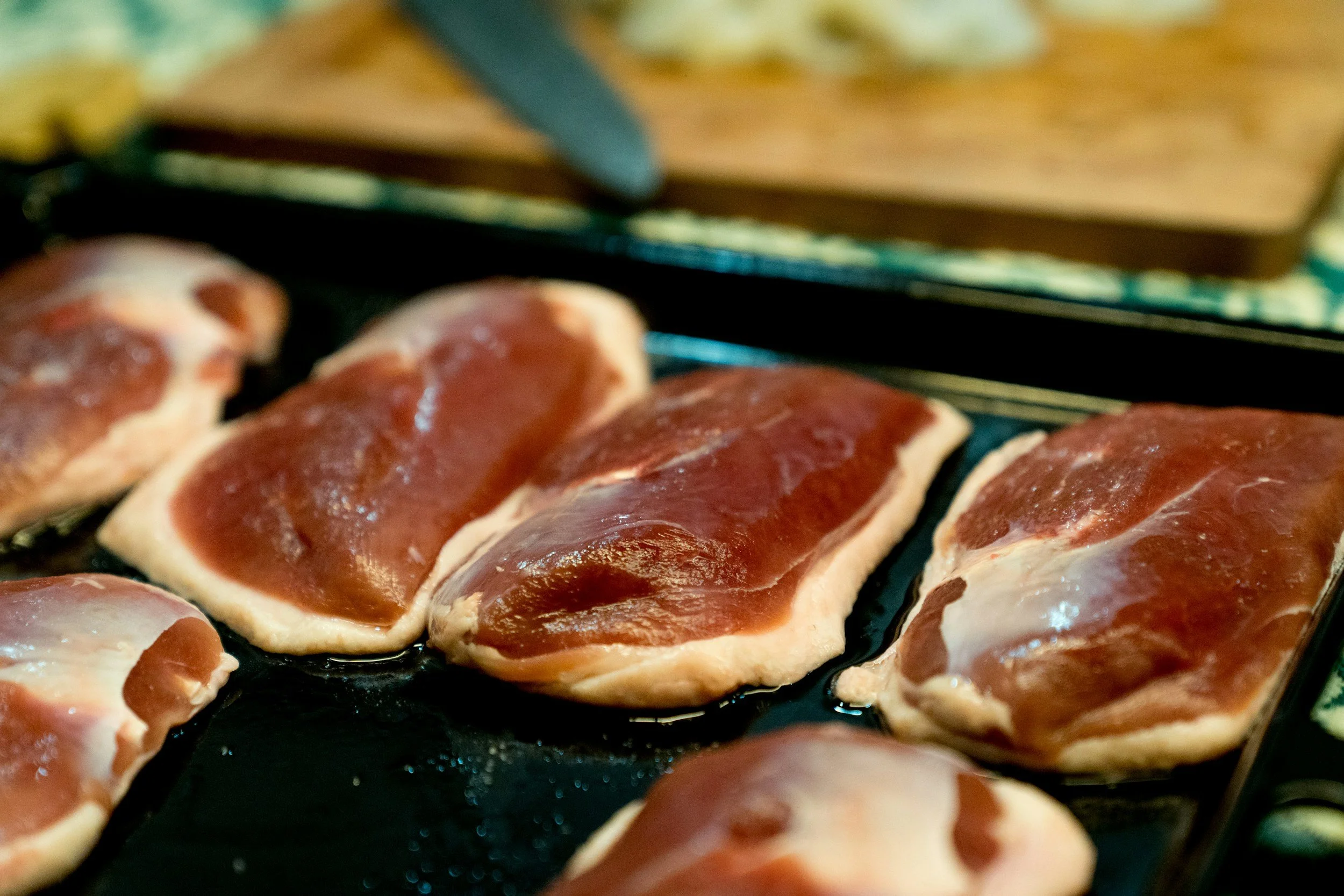 Close-up of raw inedible pork chops on a black grill.