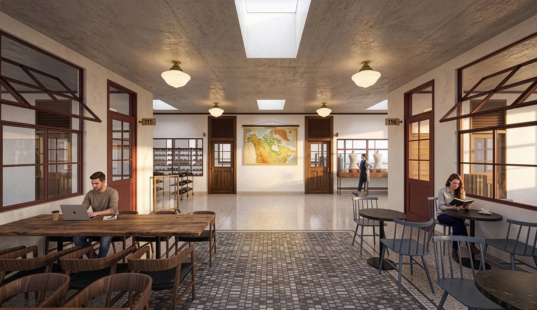 Interior of several people, including a man working on a laptop at a wooden table on the left, a woman reading a book at a small round table on the right, and a woman walking past two mannequins in the background. The space has large windows, vintage-style ceiling lights, and a map on the wall.
