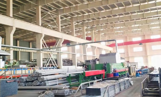 Industrial warehouse with machinery, metal pipes and construction materials.