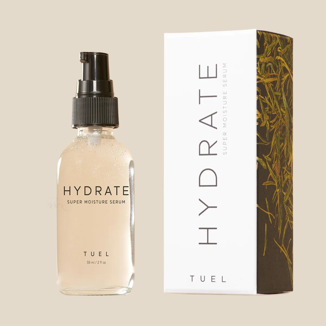 A clear glass spray bottle labeled 'HYDRATE SUPER MOISTURE SERUM' next to a white box with similar branding, with a dark side featuring an image of plant leaves.