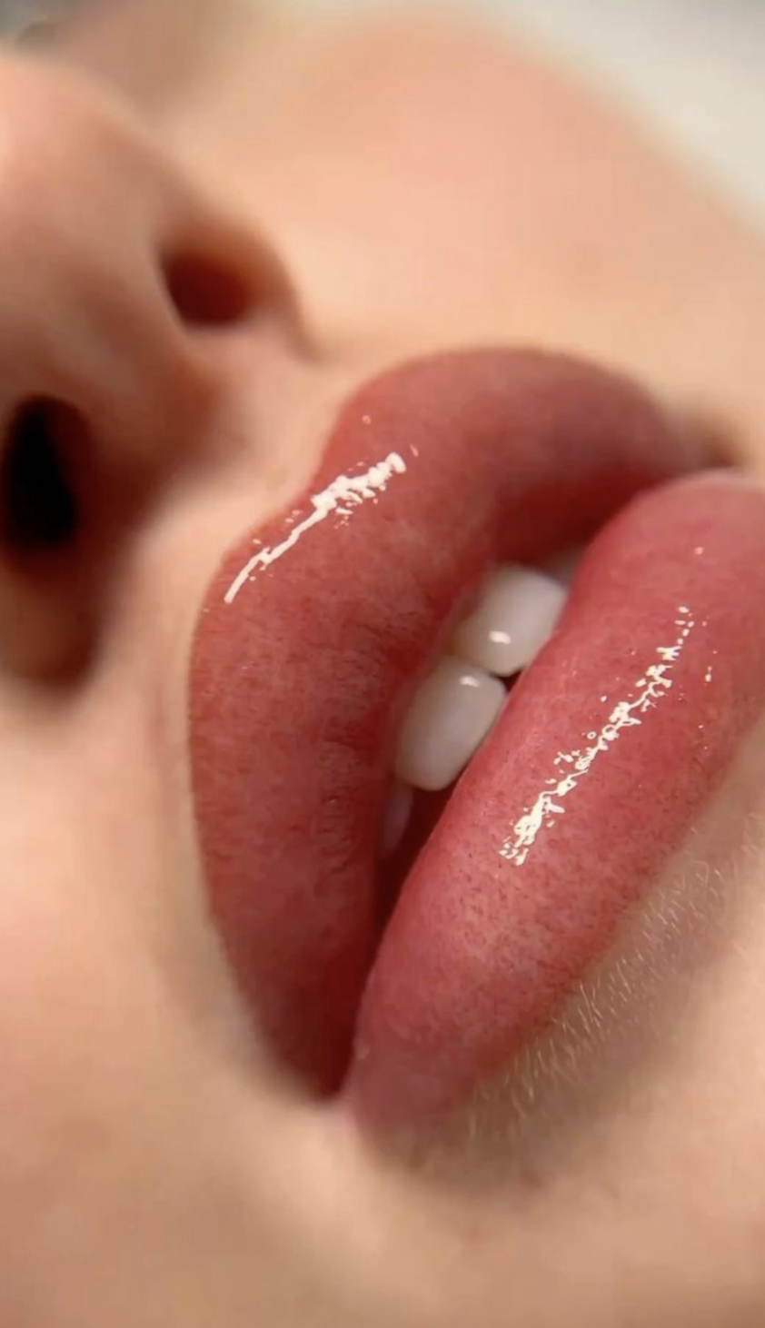 Close-up of a person's mouth with tongue out, showing lips and teeth.