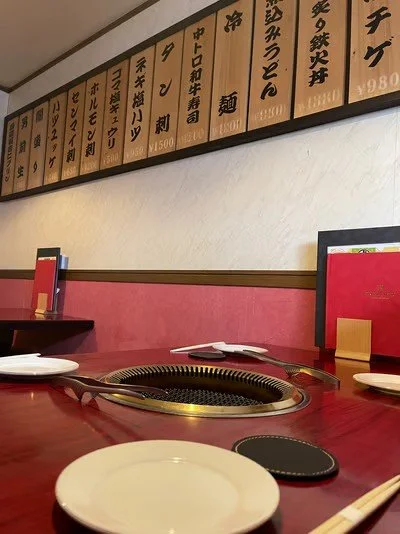 レストランのテーブルと壁に掛かっているメニュー板