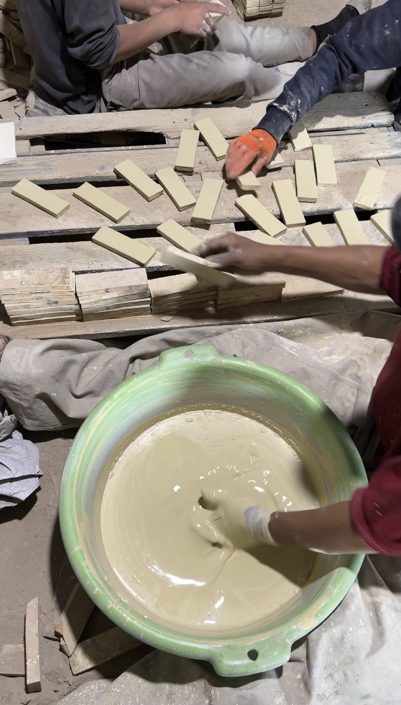 Artisans glazing handmade ceramic tiles in Fez, Morocco