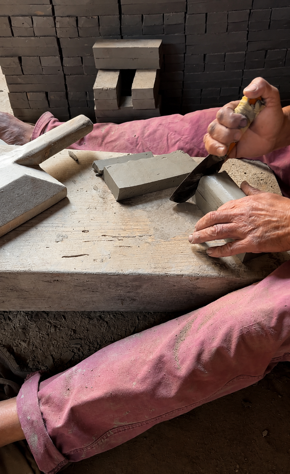 Artisan hand-shaping clay tiles in a Fez workshop