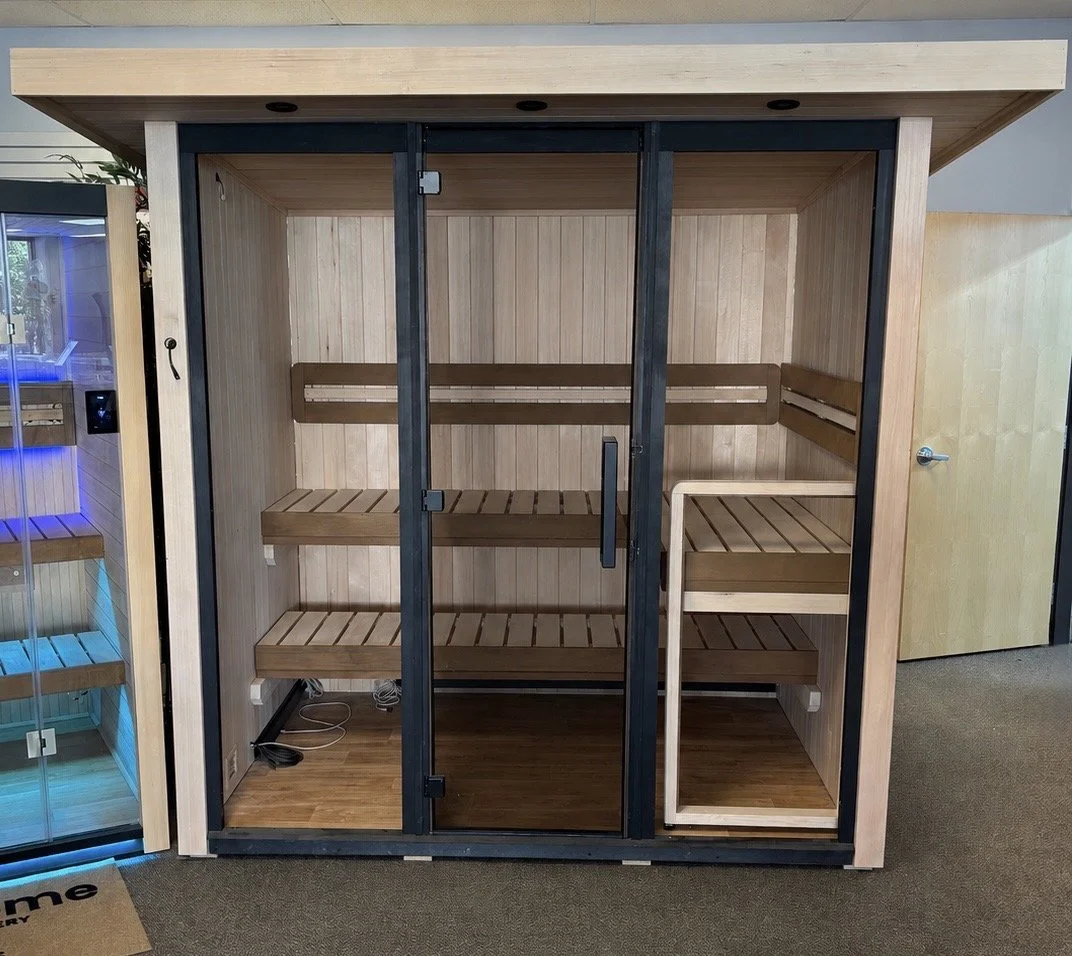 A wooden sauna with glass doors and built-in wooden benches inside.