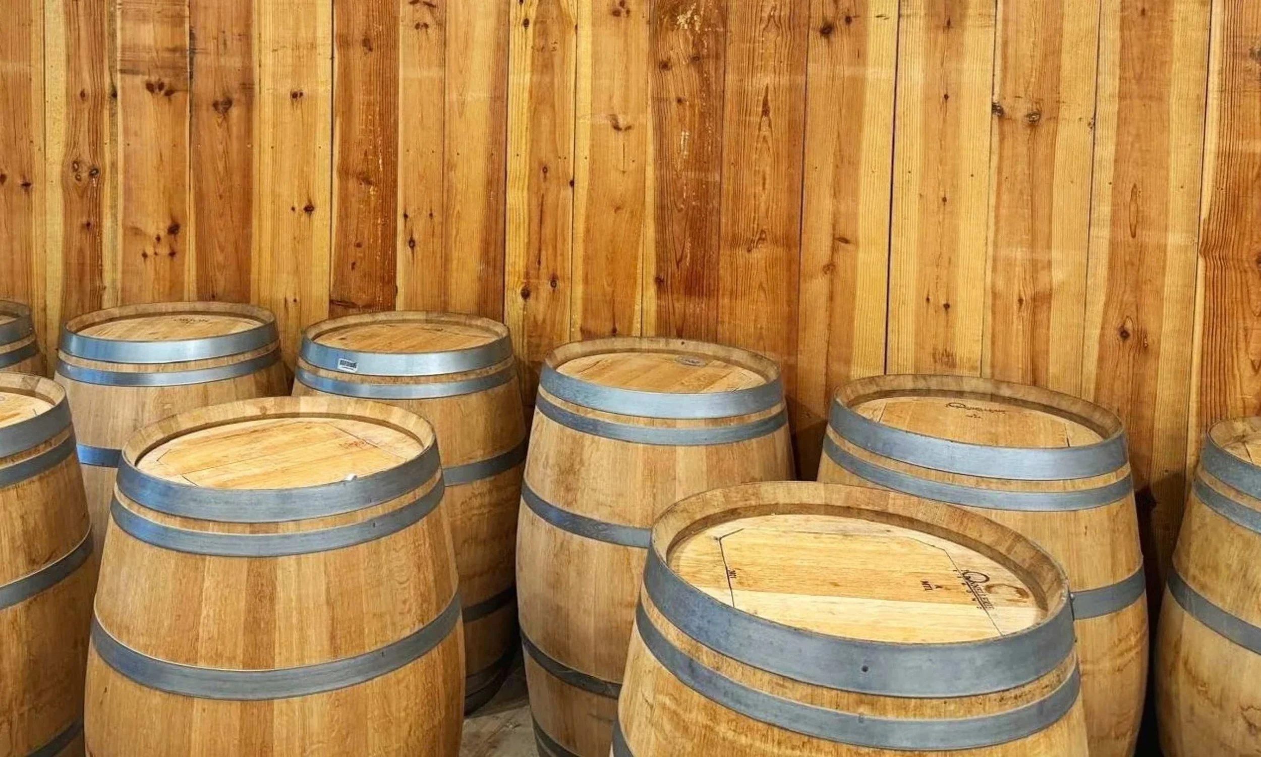 Barils en bois empilés contre un mur en bois.