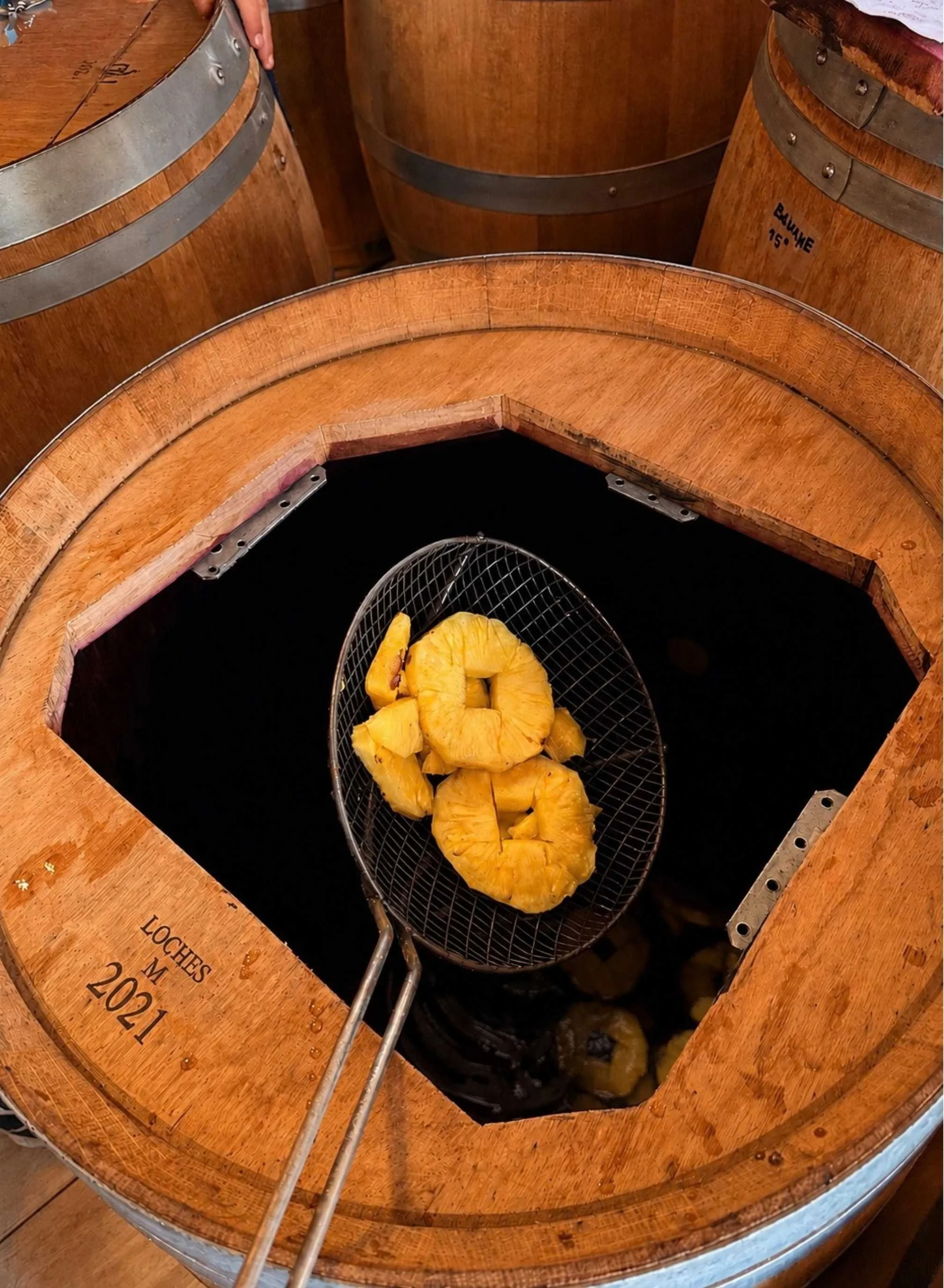 Fruits coupés à l'intérieur d'un tonneau en bois avec une grille et une pince en métal