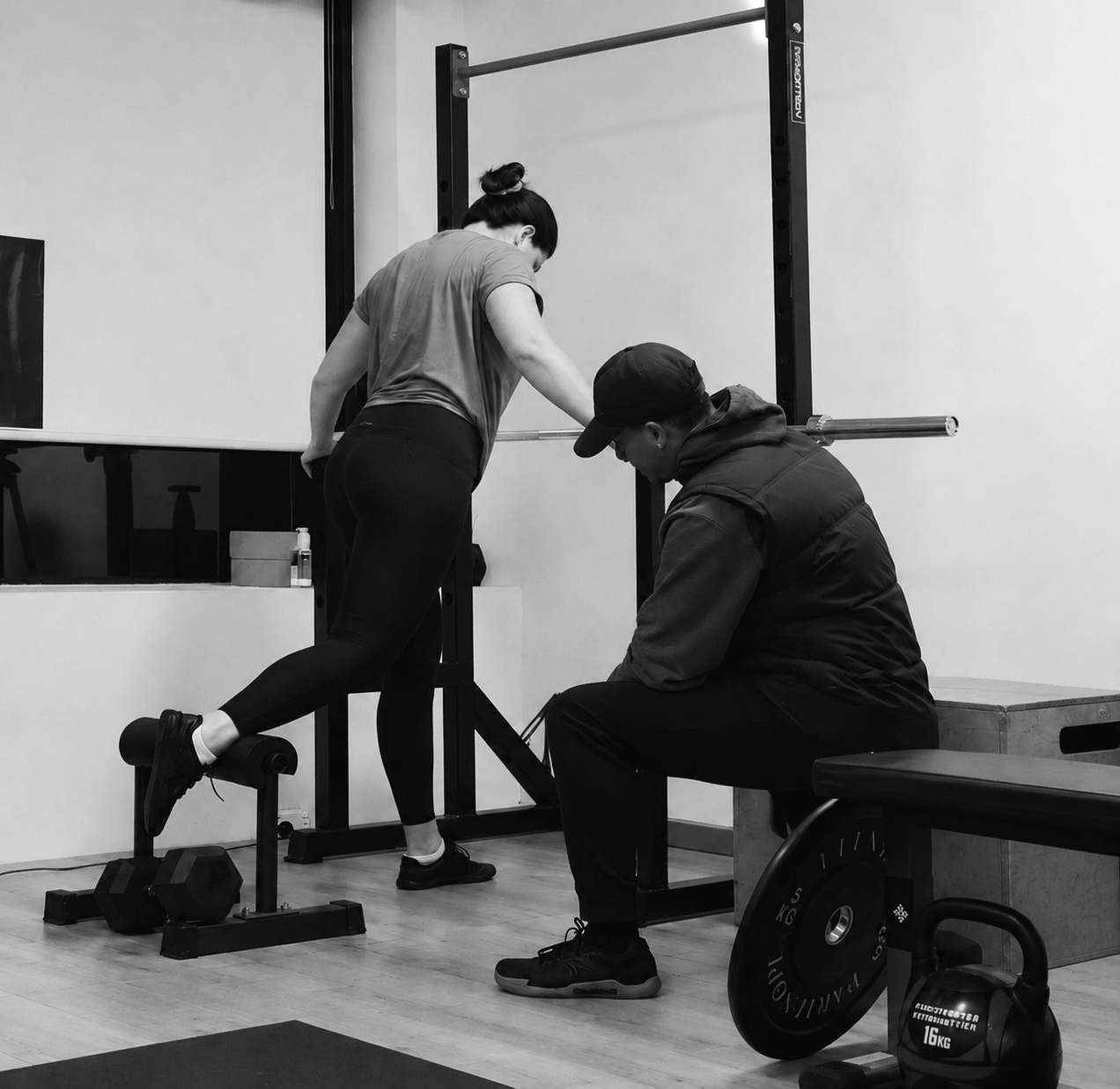Personal trainer helping client with her lunge