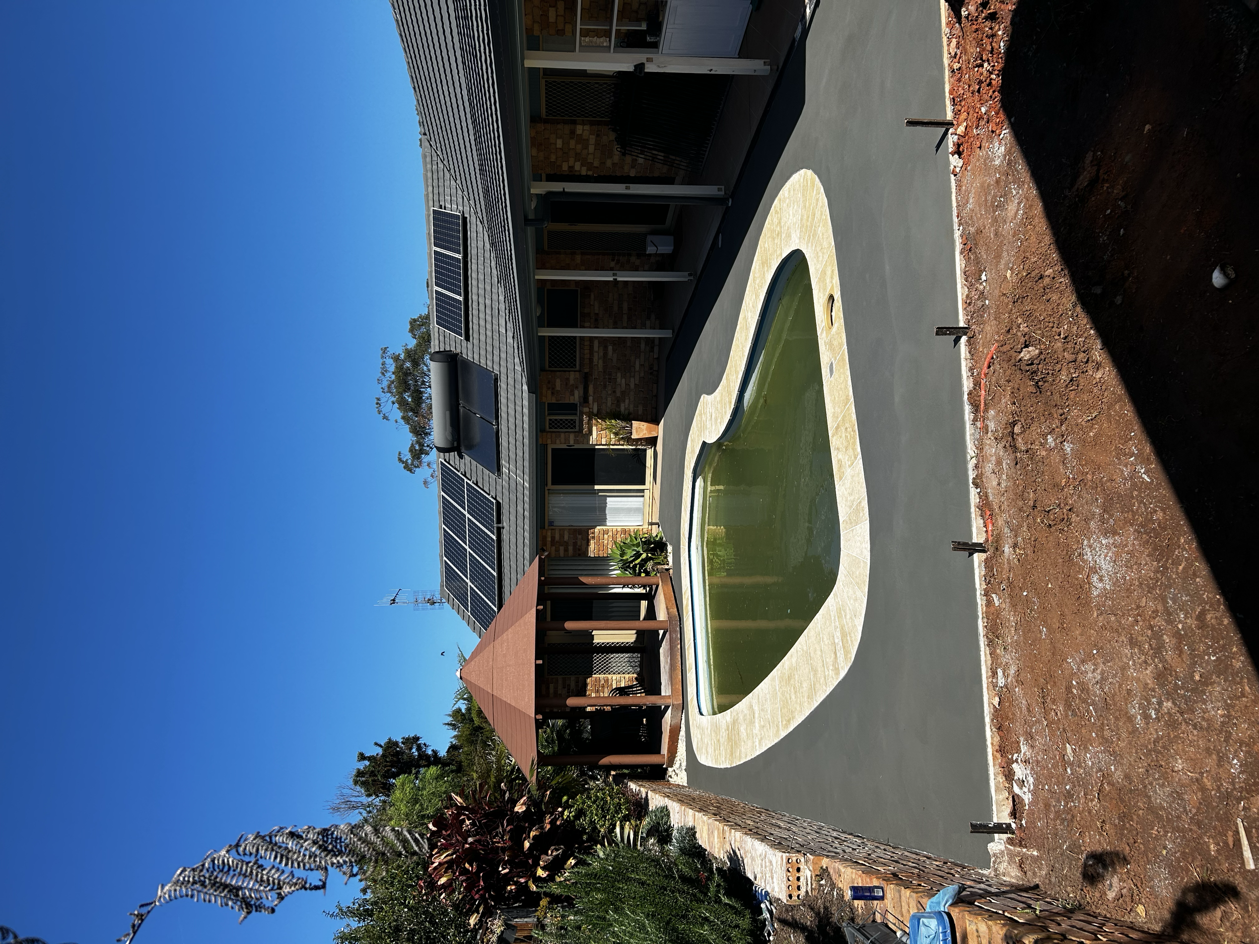 Freshly poured concrete outside of the in-ground pool. Construction site. 
