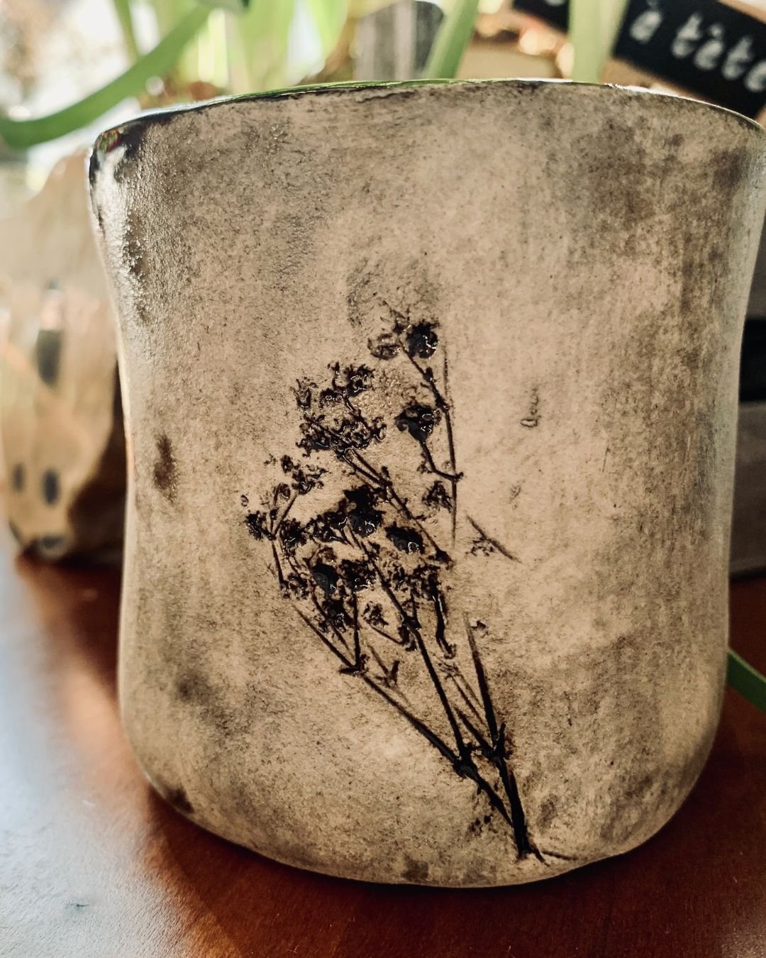 Keramiktopf mit getrockneten Blumen und Graffiti-Design, auf Holzoberfläche
