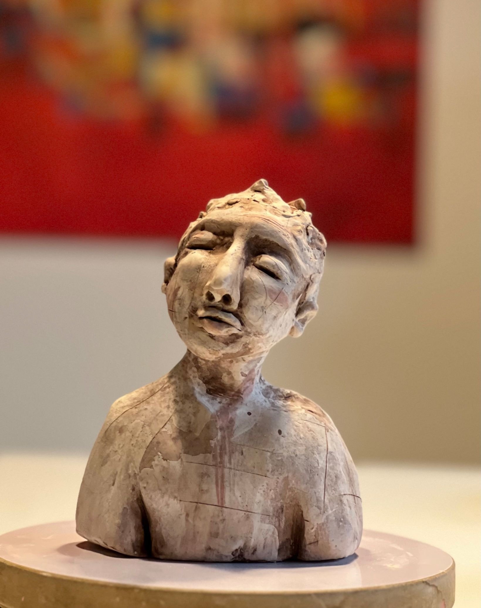 Skulptur eines menschlichen Kopfes aus Marmor, die auf einer Basis steht.