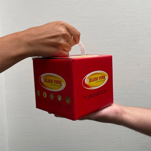 Deux mains, une tenant une boîte rouge étiquetée 'ELIDE FIRE' et l'autre la recevant, sur un fond gris clair.
