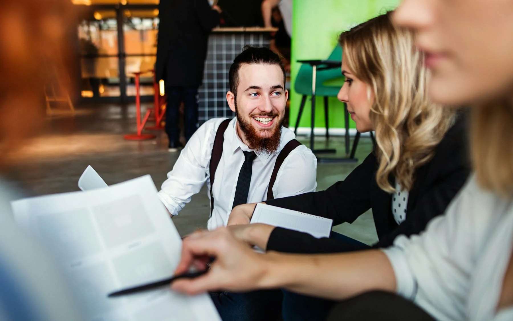 A group of young professionals engaged in a discussion at a meeting.