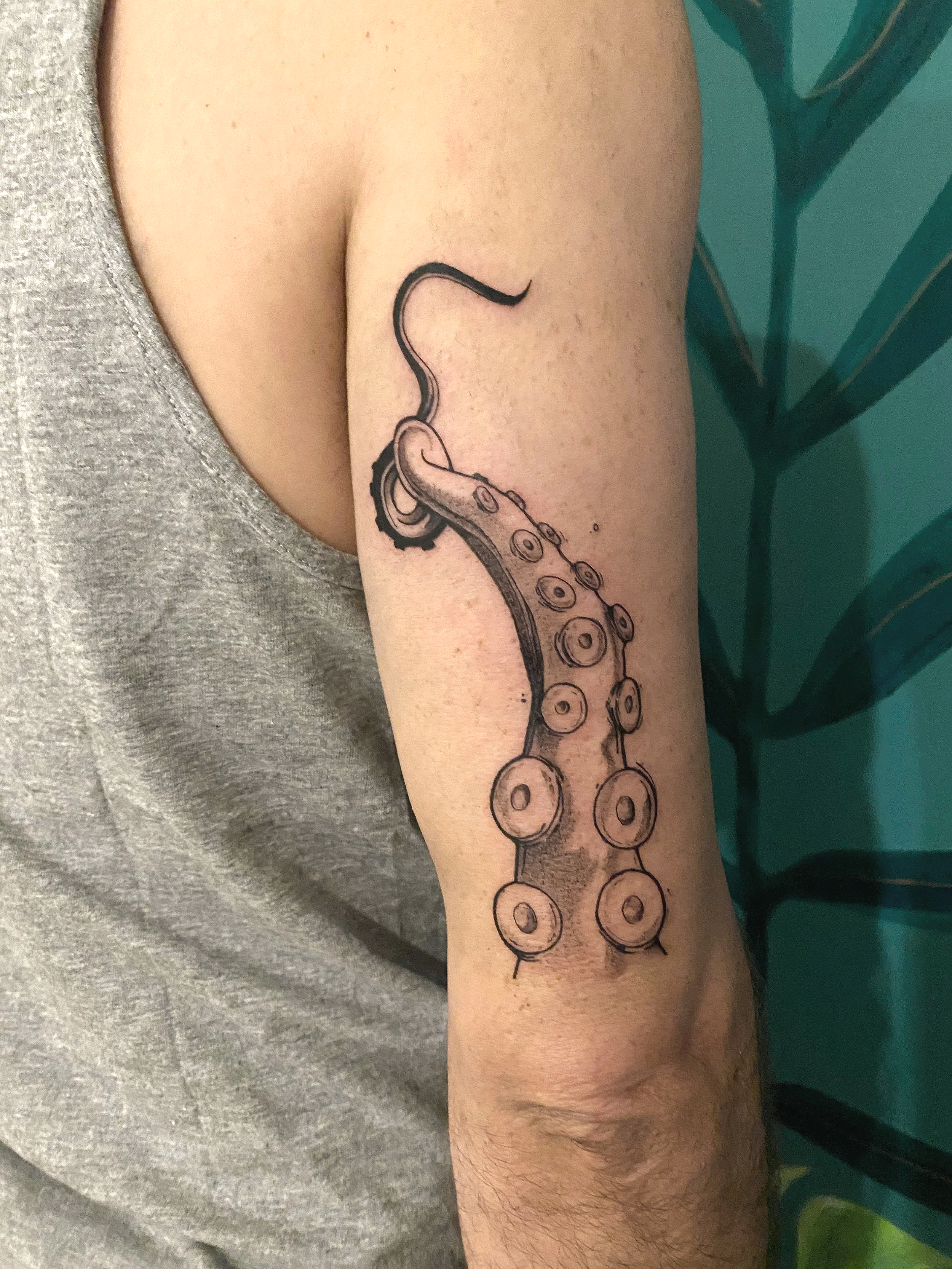 Tatouage d'une tentacule de poulpe sur le bras d'une personne.