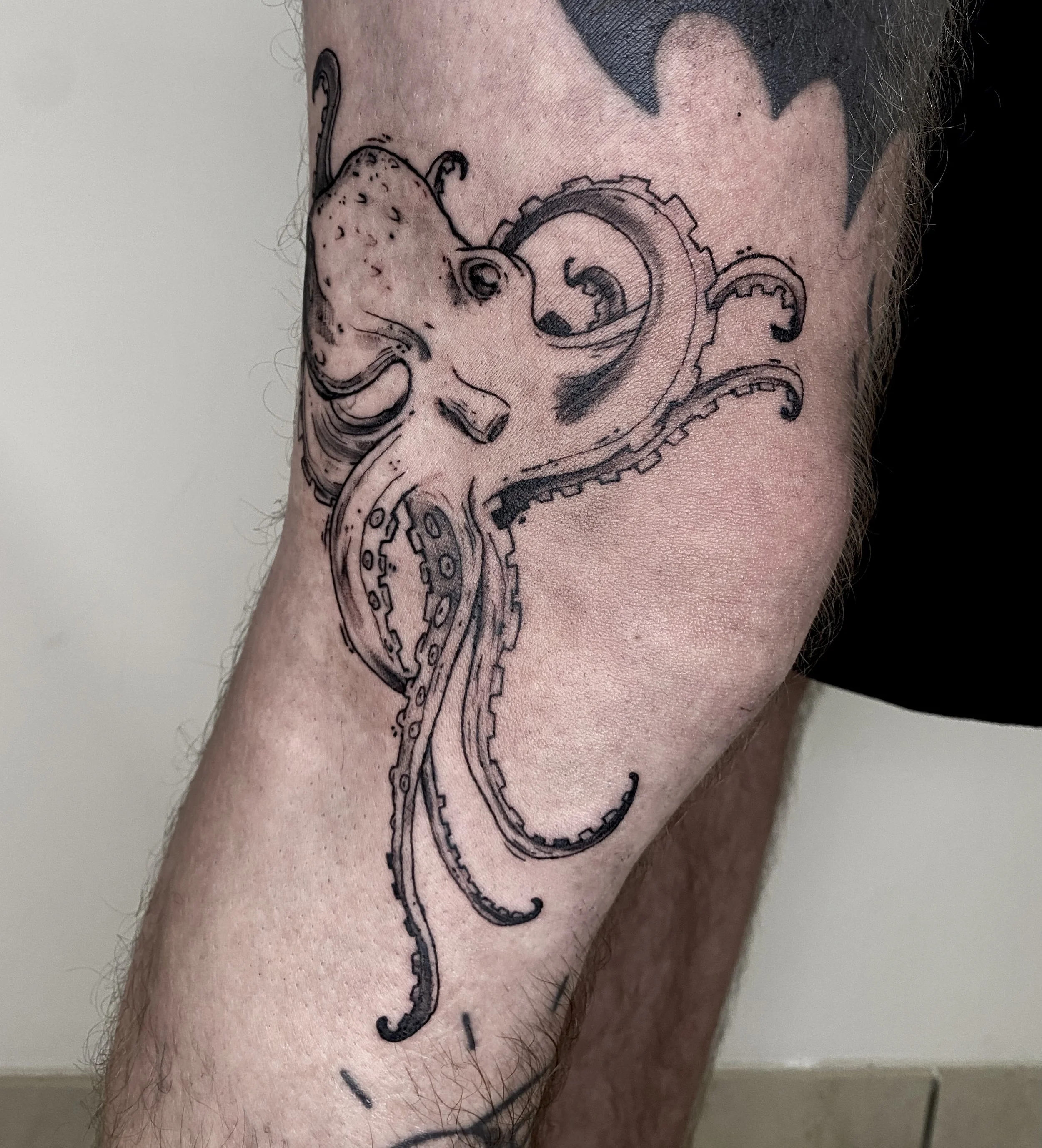 Tatouage d'un poulpe en style dessin sur le bras d'une personne