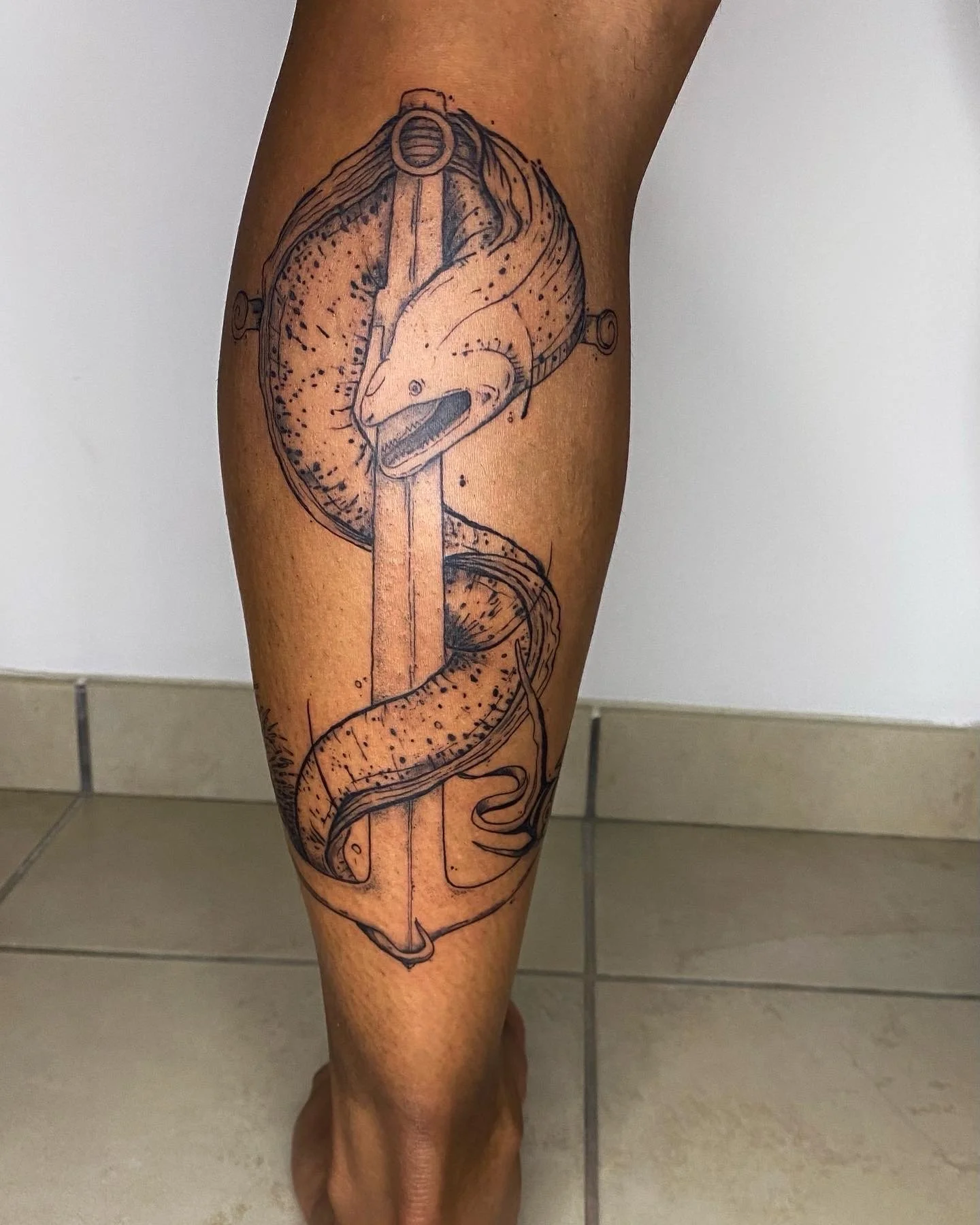 Tatouage d'une murène autour d'une ancre