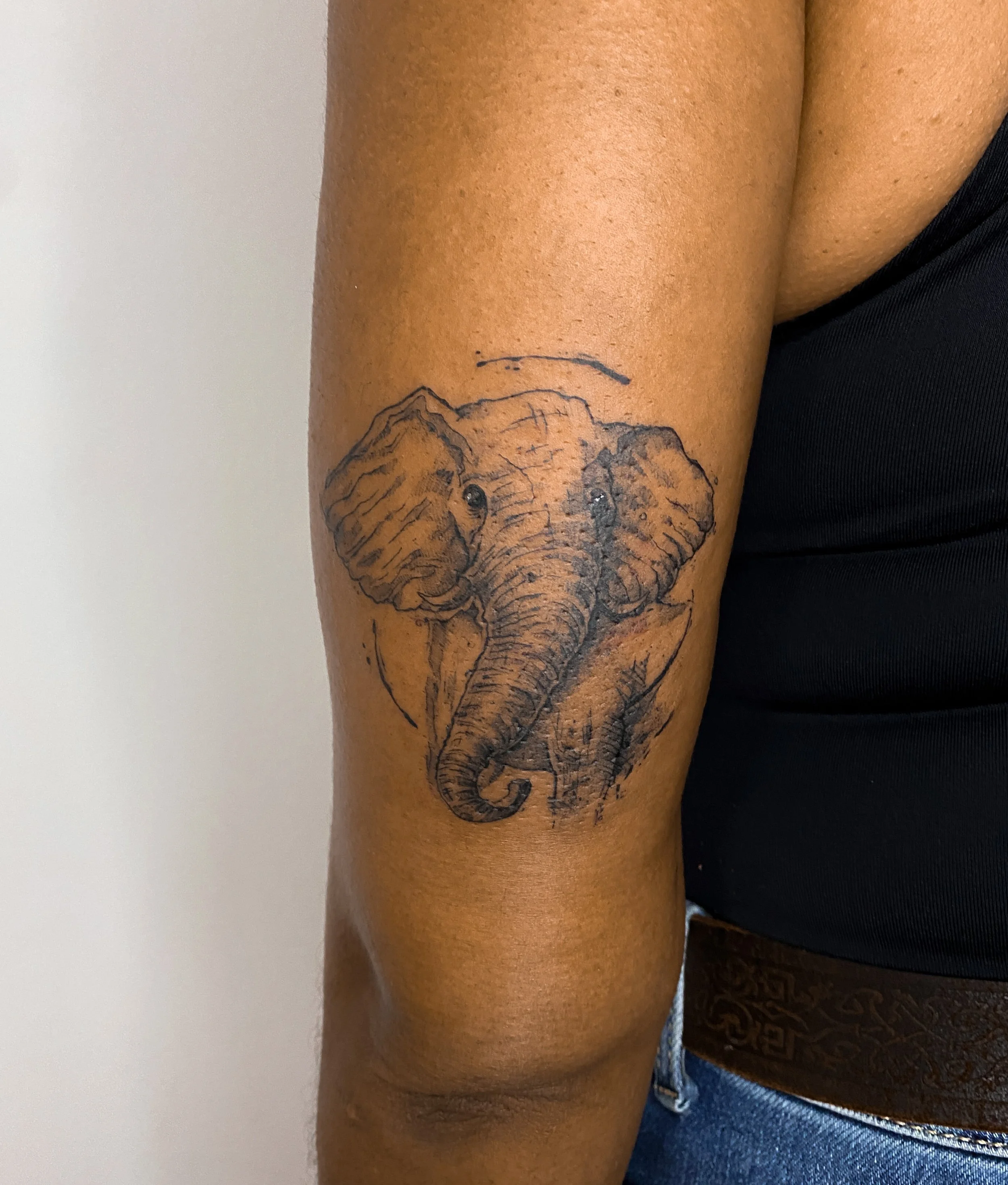 Tatouage d'un éléphant en dégradé noir sur le bras d'une personne