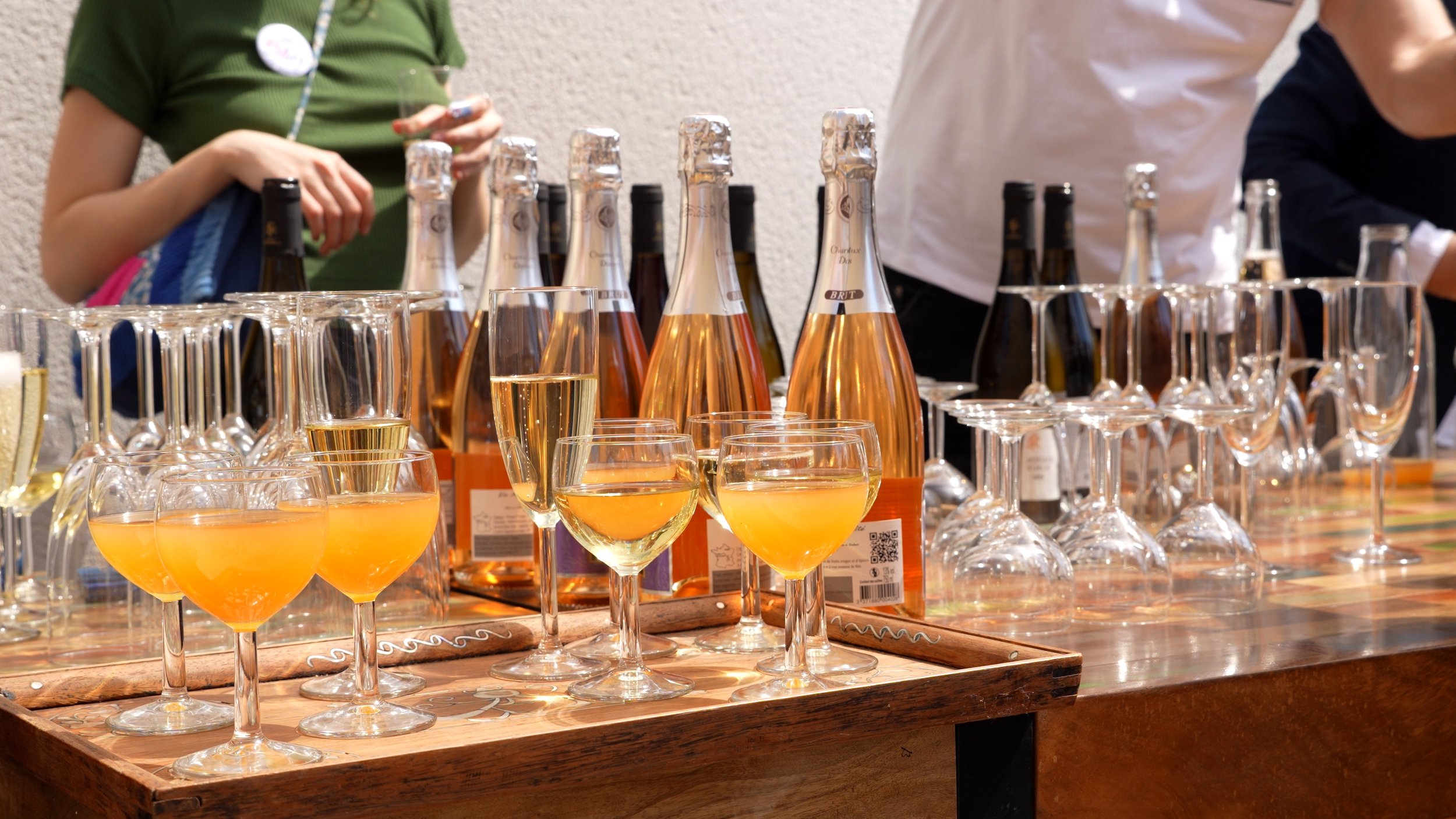 Verres et bouteilles de champagne rosé sur une table en bois lors d'une dégustation.