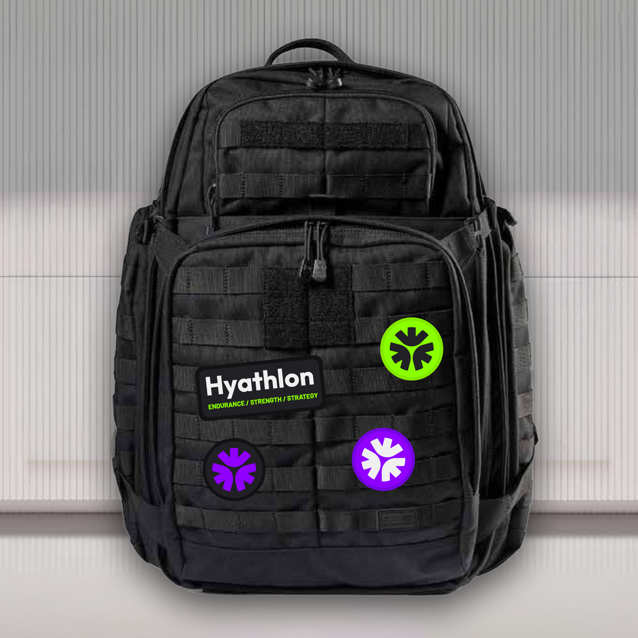 Een zwarte rugzak met stickers, waaronder een Hyathlon sticker en kleurrijke symbolen, geplaatst voor een witte, textured achtergrond.