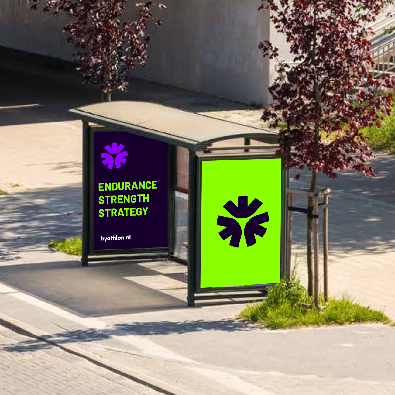 Een bushokje met een advertentie die de woorden 'ENDURANCE STRENGTH STRATEGY' en de website 'hyathlon.nl' toont, en een groene achtergrond met een zwart symbool.