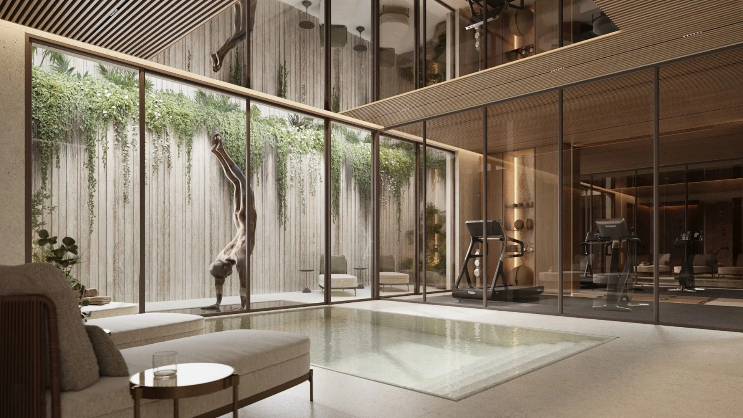 Modern indoor gym with large glass windows, a small indoor pool, exercise machines, and greenery visible outside.