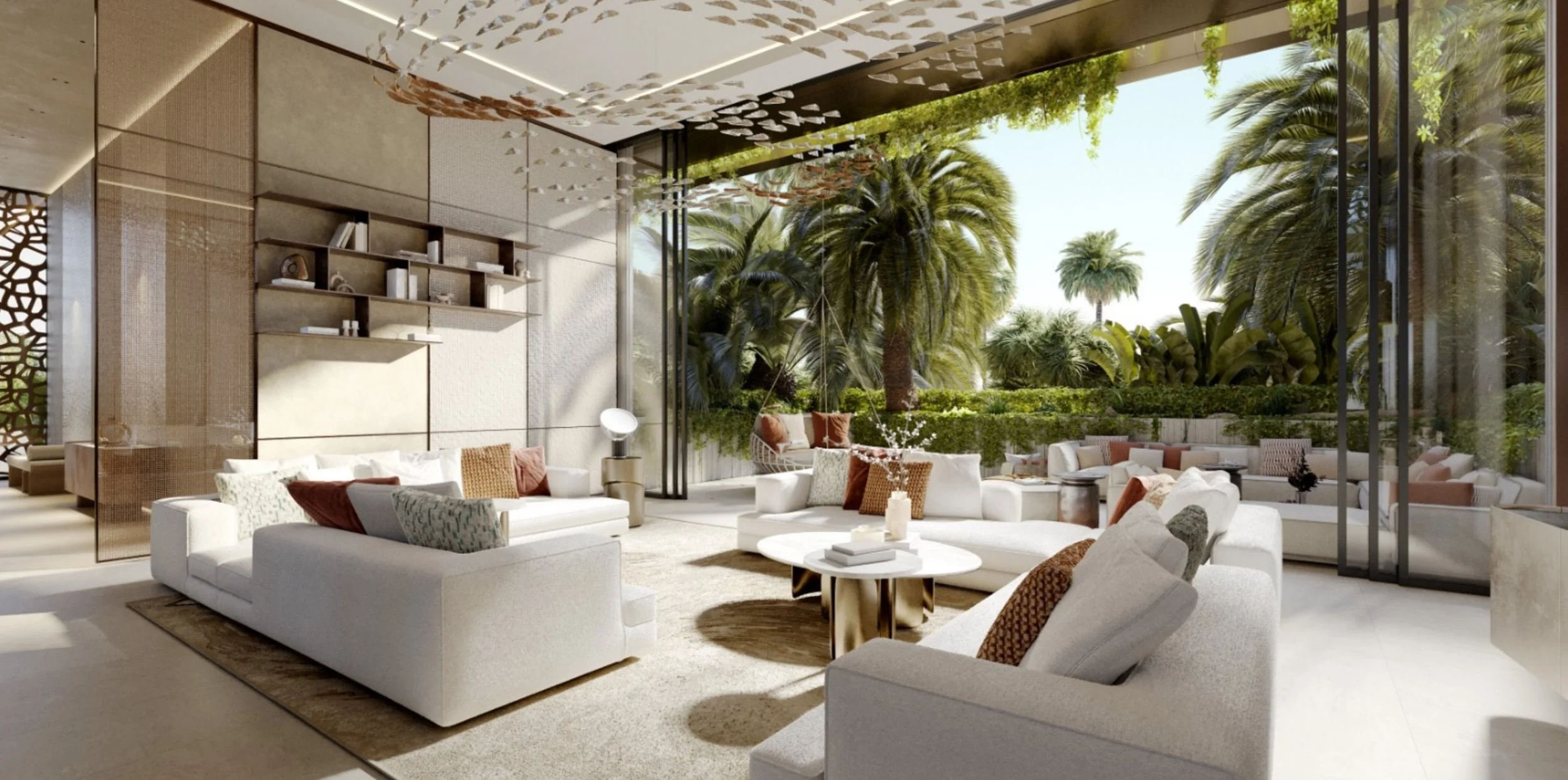 Modern living room with white sofas, pillows, and a coffee table, featuring large glass windows overlooking a lush garden with tall palm trees.