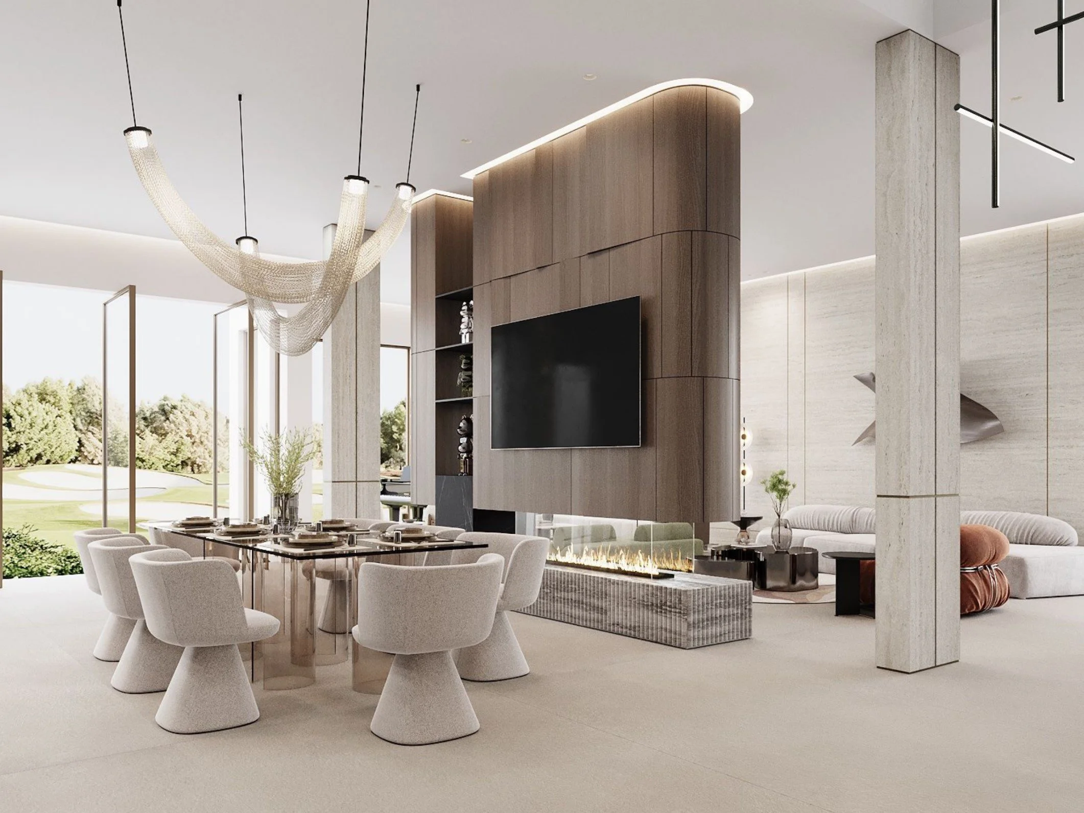 Modern living room with a large dining table surrounded by white chairs, a sitting area with a fireplace, a mounted flat-screen TV, and large windows with a view of greenery outside.