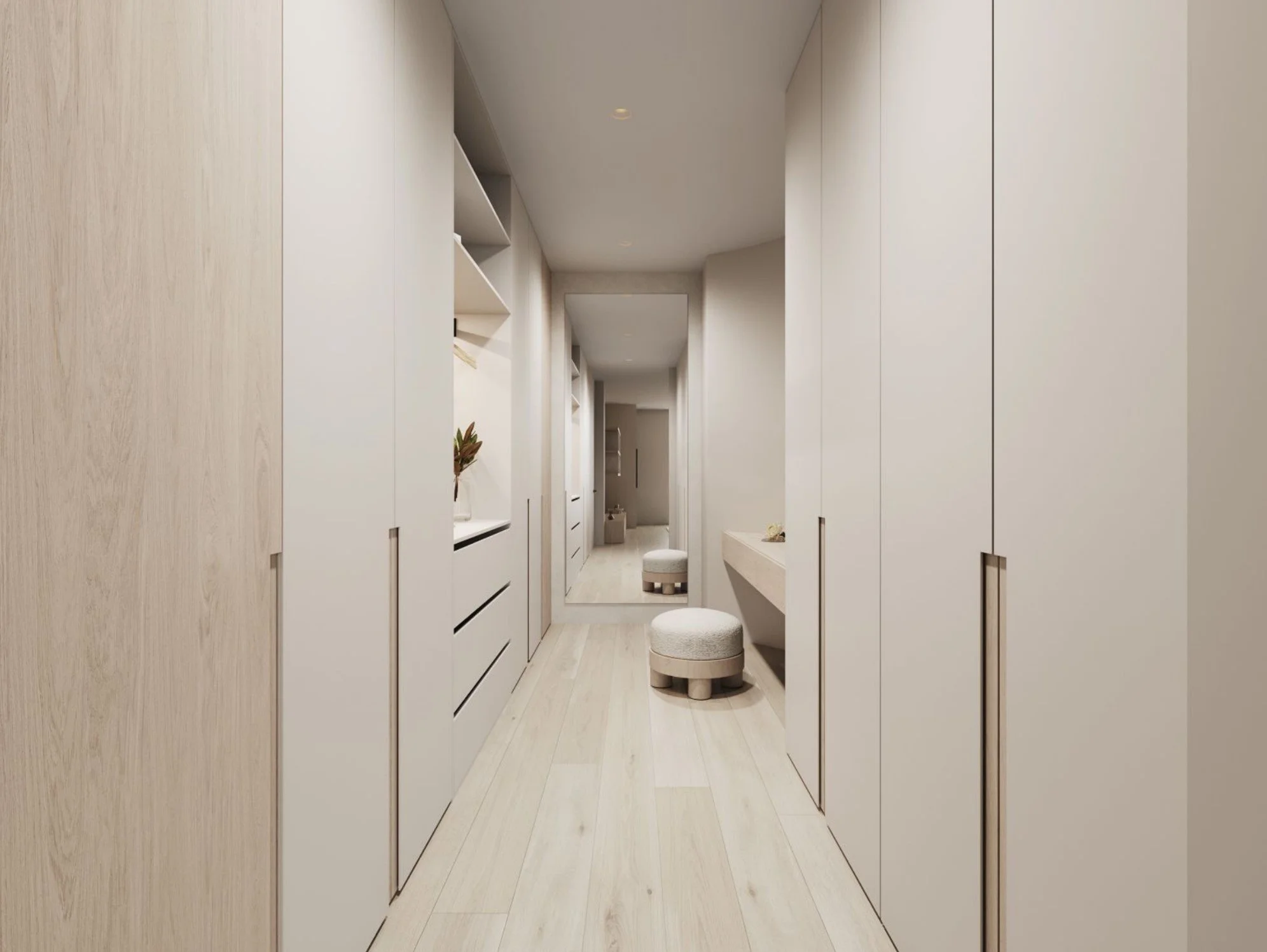 A modern, minimalist hallway with light wood floors, white cabinetry on both sides, a mirror at the end, and small round upholstered stools.