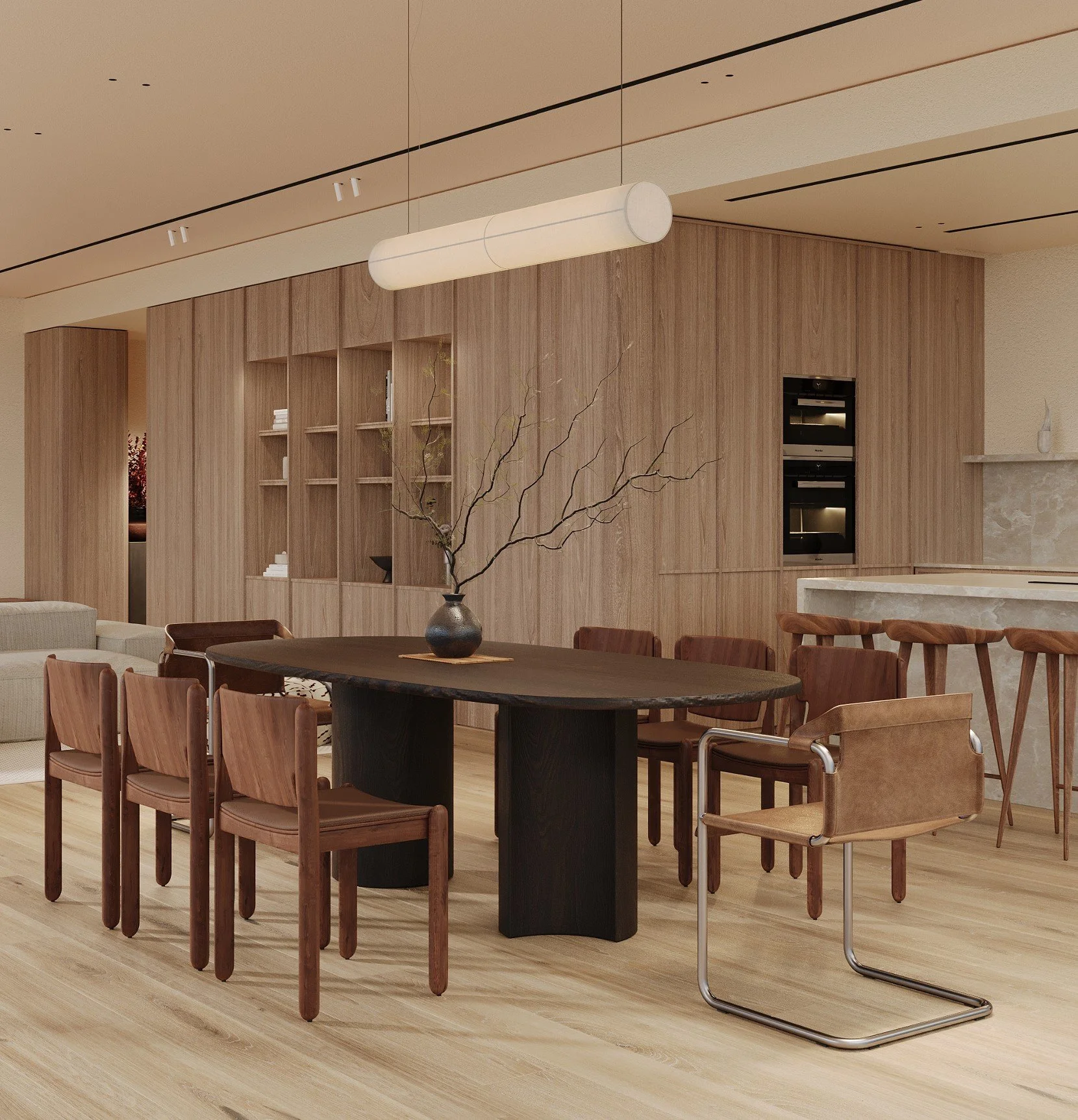 Modern dining area with wooden chairs around a dark oval table, a decorative branch in a black vase, and wooden wall panels with built-in ovens in the background.