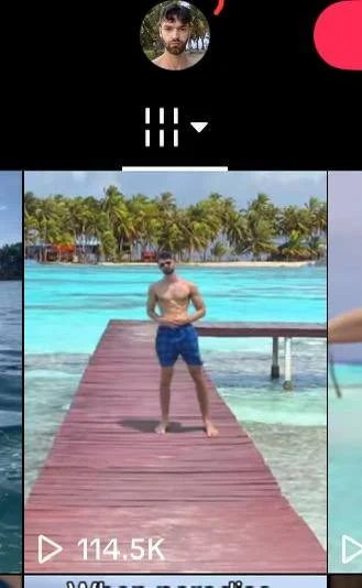 Man standing on a wooden pier over turquoise tropical water with palm trees in the background