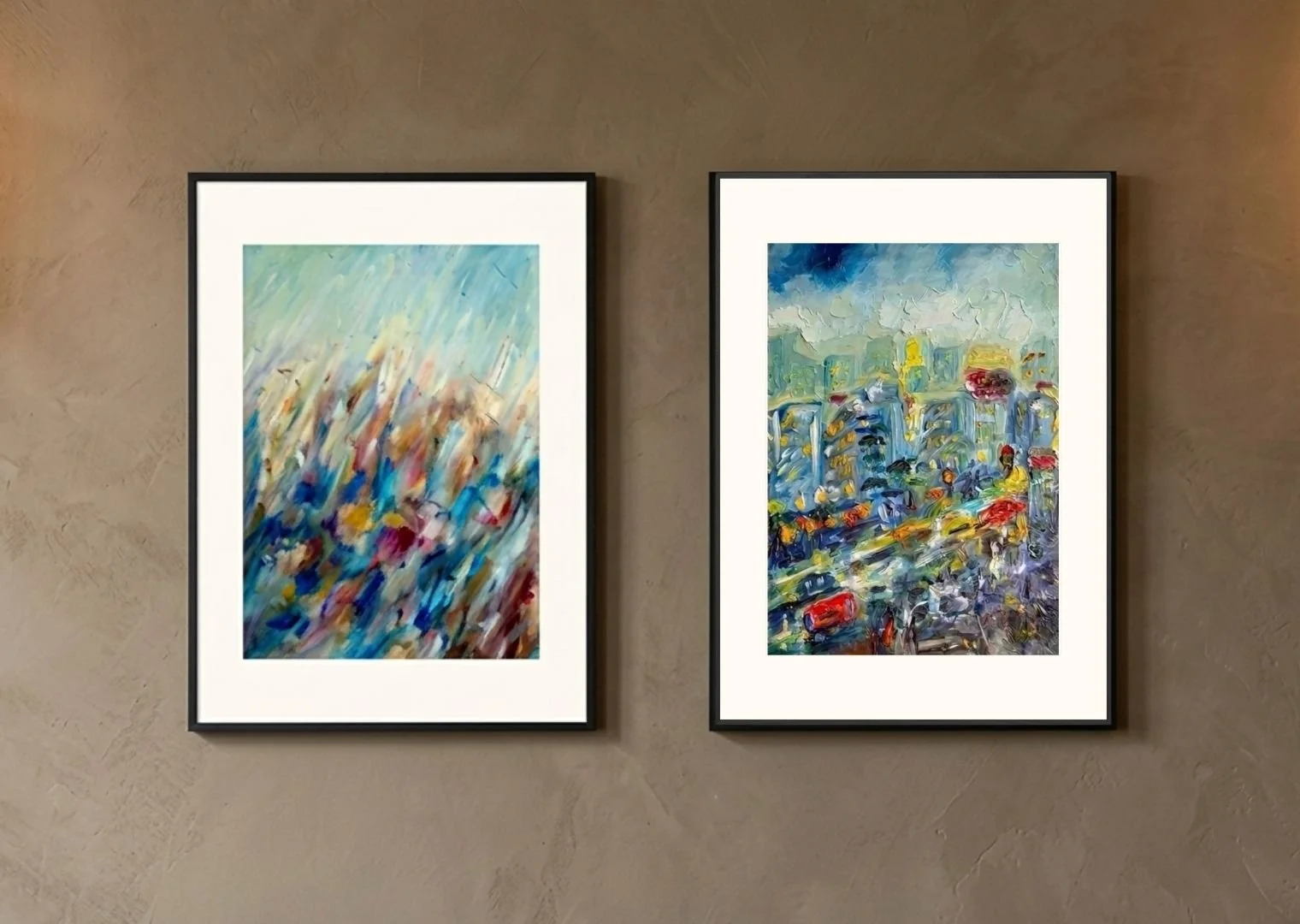 Two framed abstract paintings hung side by side on a beige wall.