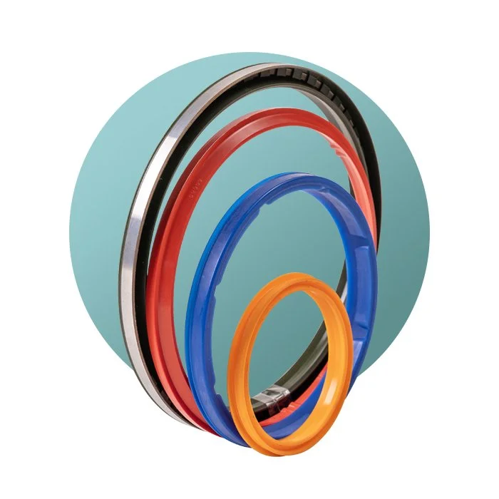 A set of colorful bicycle or mechanical seals or rings in black, red, blue, and orange, placed in front of a light blue background.