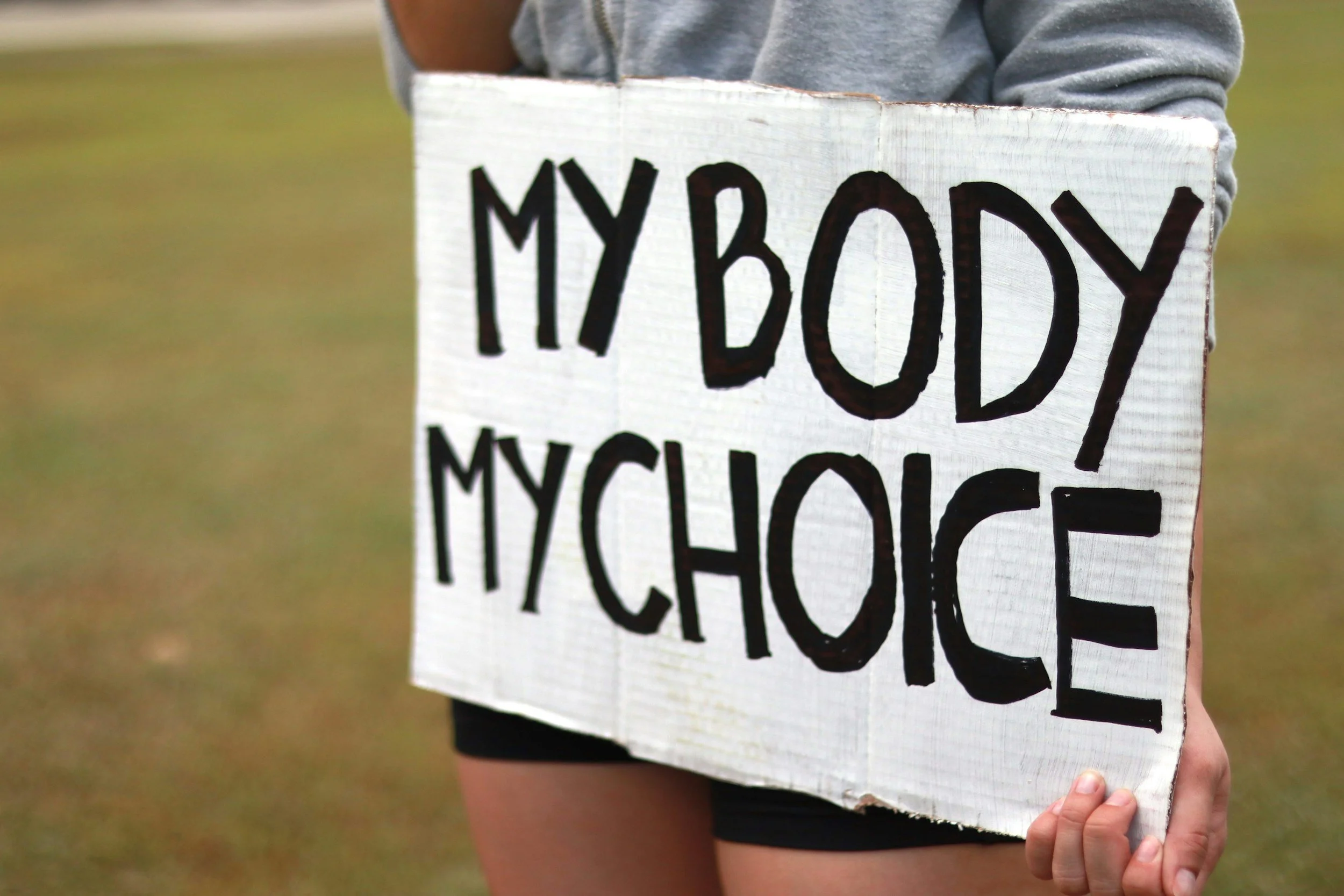 Person holding sign 'my body my choice'