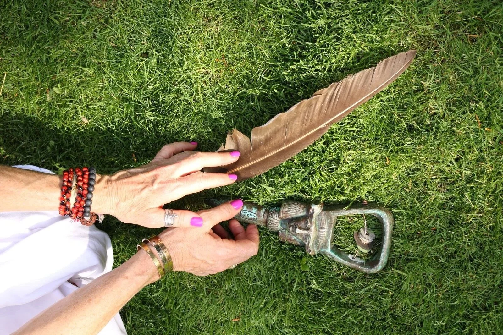Stephanie with Aummagate altar in the grass Egyptian Hathor sistrum and hawk feather