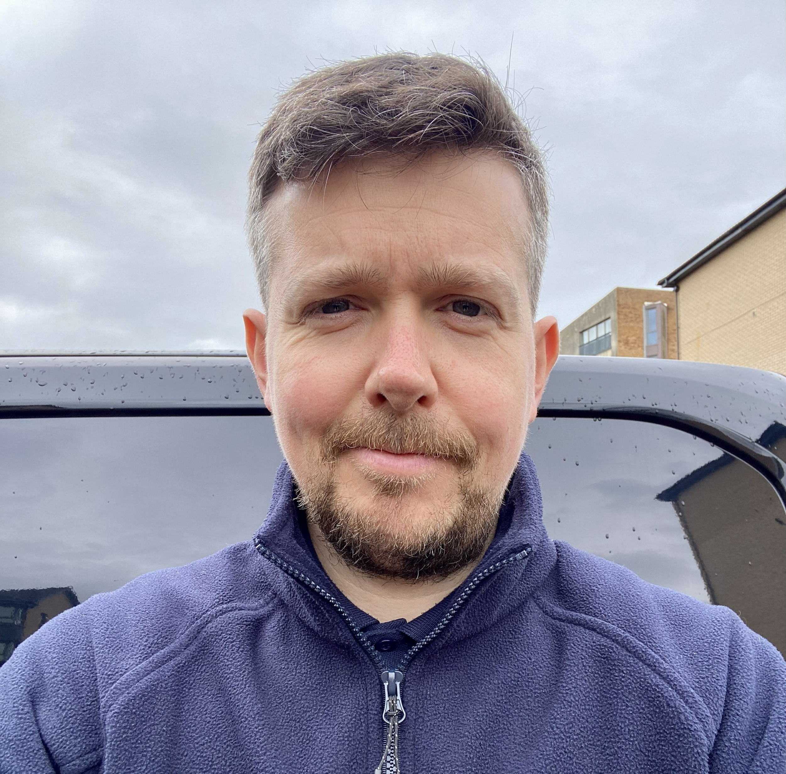 Tinto Cleaning Services team member, Alasdair, outdoors in Paisley beside a work vehicle.