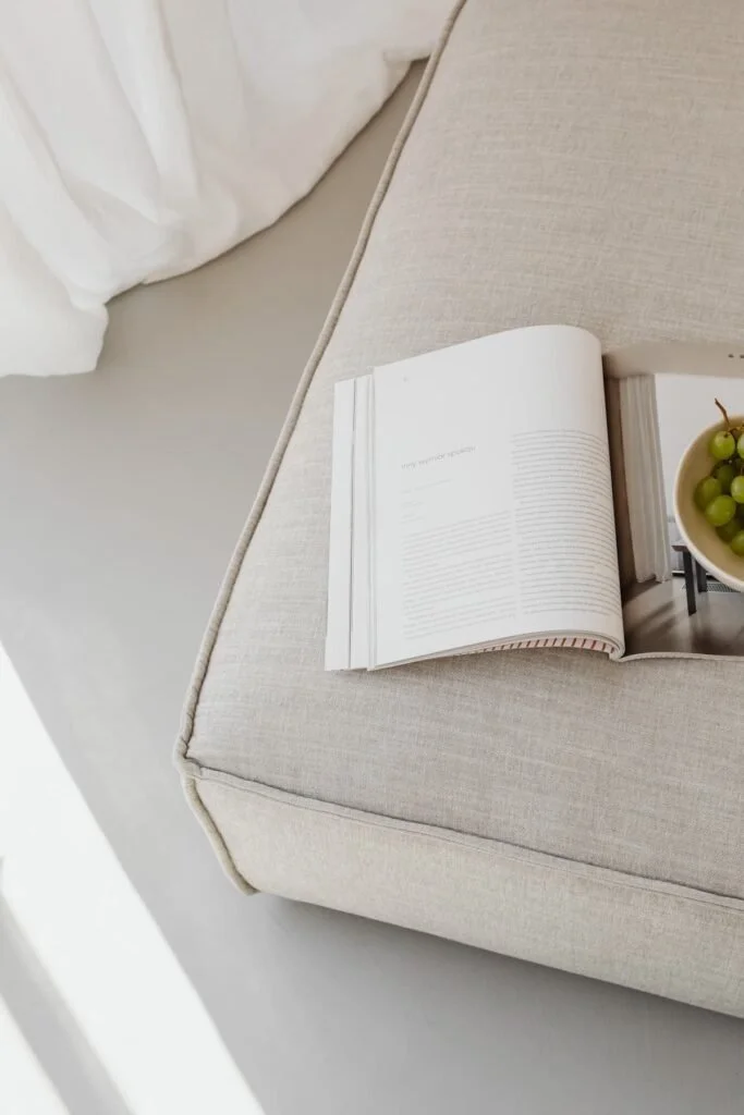 Hocker mit Bildband und einer Schale heller Trauben
