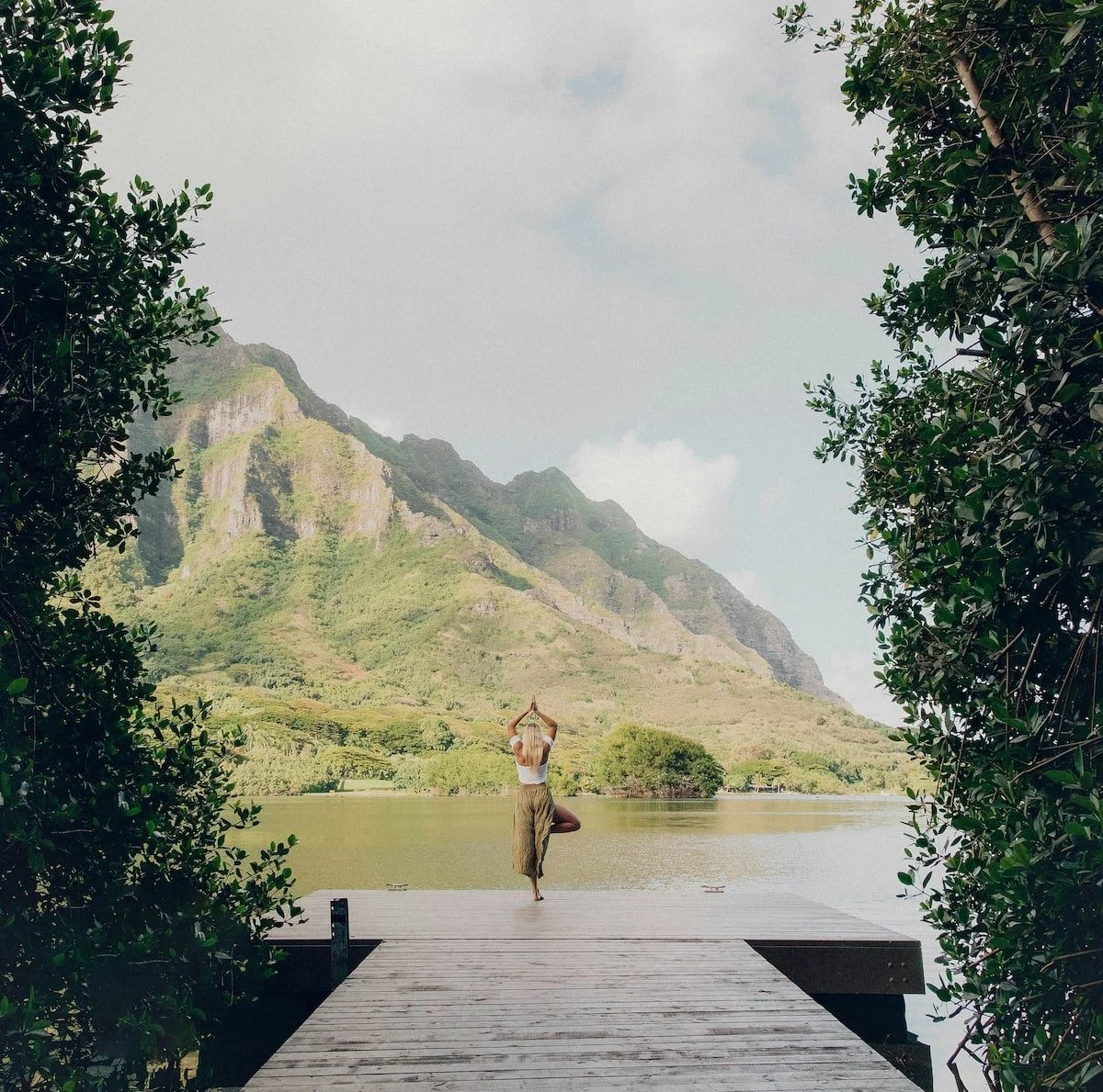 Frau macht Yoga am See auf einem Steg