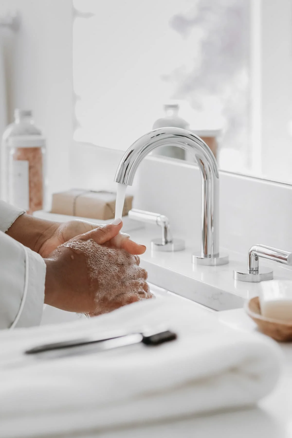 Frau wäscht sich in einem minimalistischen Badezimmer achtsam die Hände