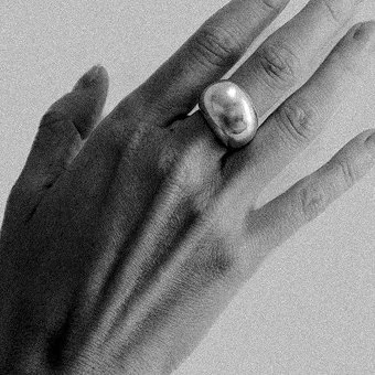 Frauenhand mit Silberring am Mittelfinger