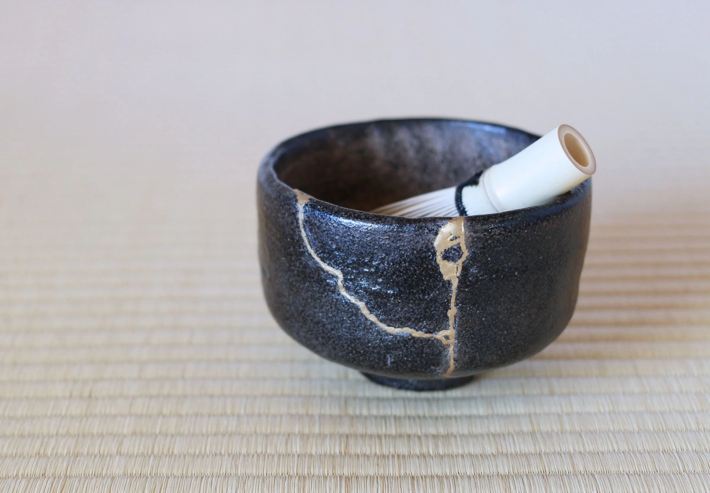 schwarze Schale zeigt die sogenannte Goldreparatur: Kintsugi