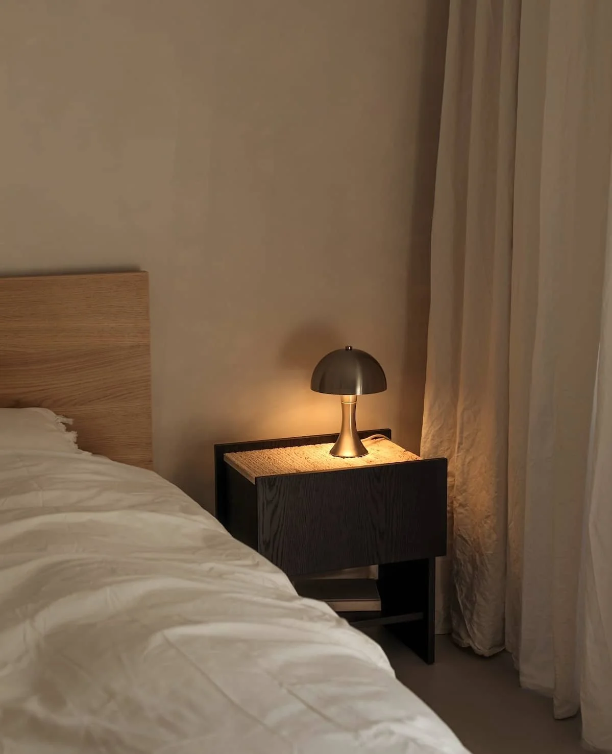 Abendliches Schlafzimmer im warmen Licht einer Nachttischleuchte