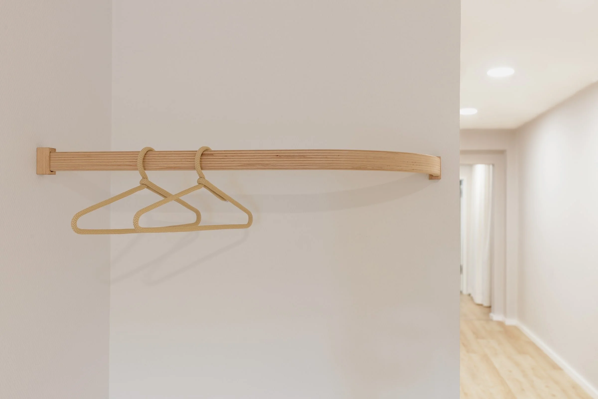 individuell angefertigte, minimalistische Garderobe aus gebogenem Holz