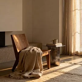 Holzsessel vor Kamin in einem sonnig warmen Raum