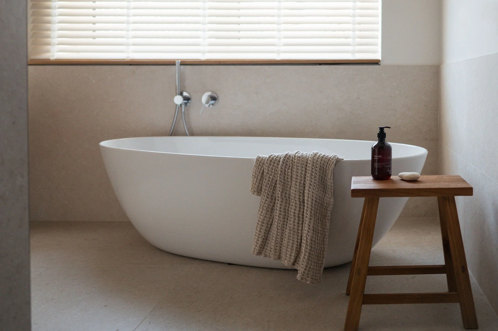Freistehende Badewanne mit einem japanischen Hocker davor