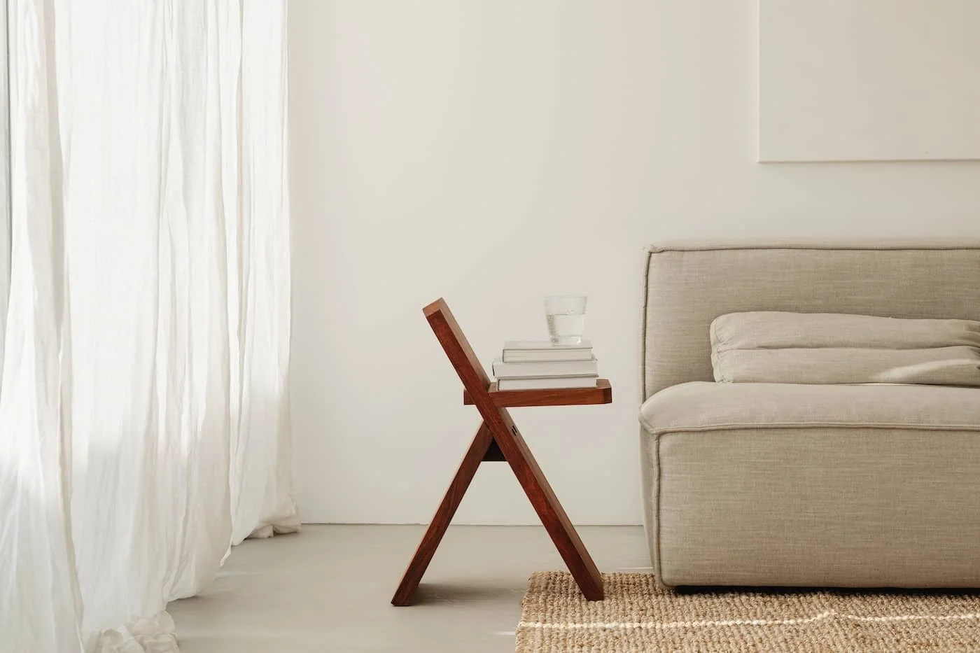 Minimalistisches Sofa mit leinenfarbenem Bezug auf Sisalteppich