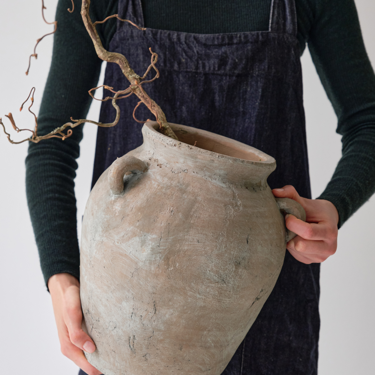 Frau mit großem naturfarbenem Keramikkrug in der Hand