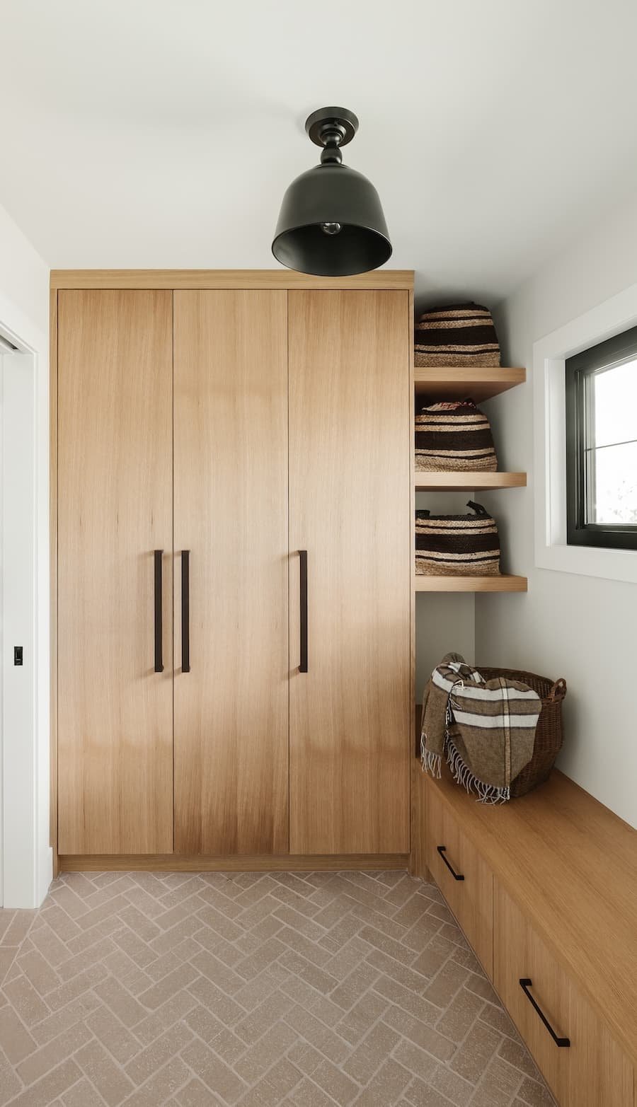 Eingangsbereich mit geschlossener Garderobe und Fischgrätfliesenboden