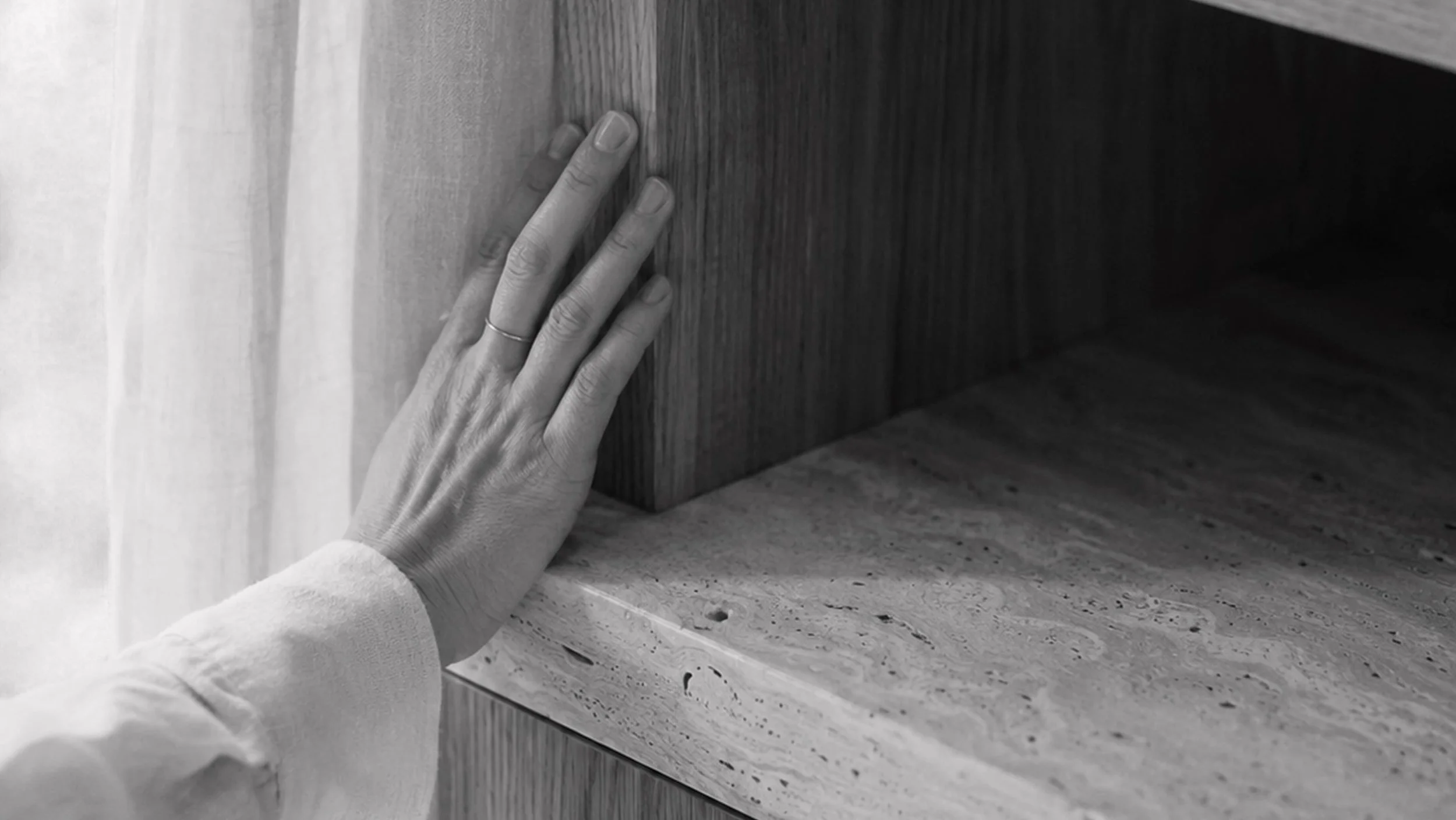 Eine Hand berührt eine Holzplatte auf einer Steintreppe.