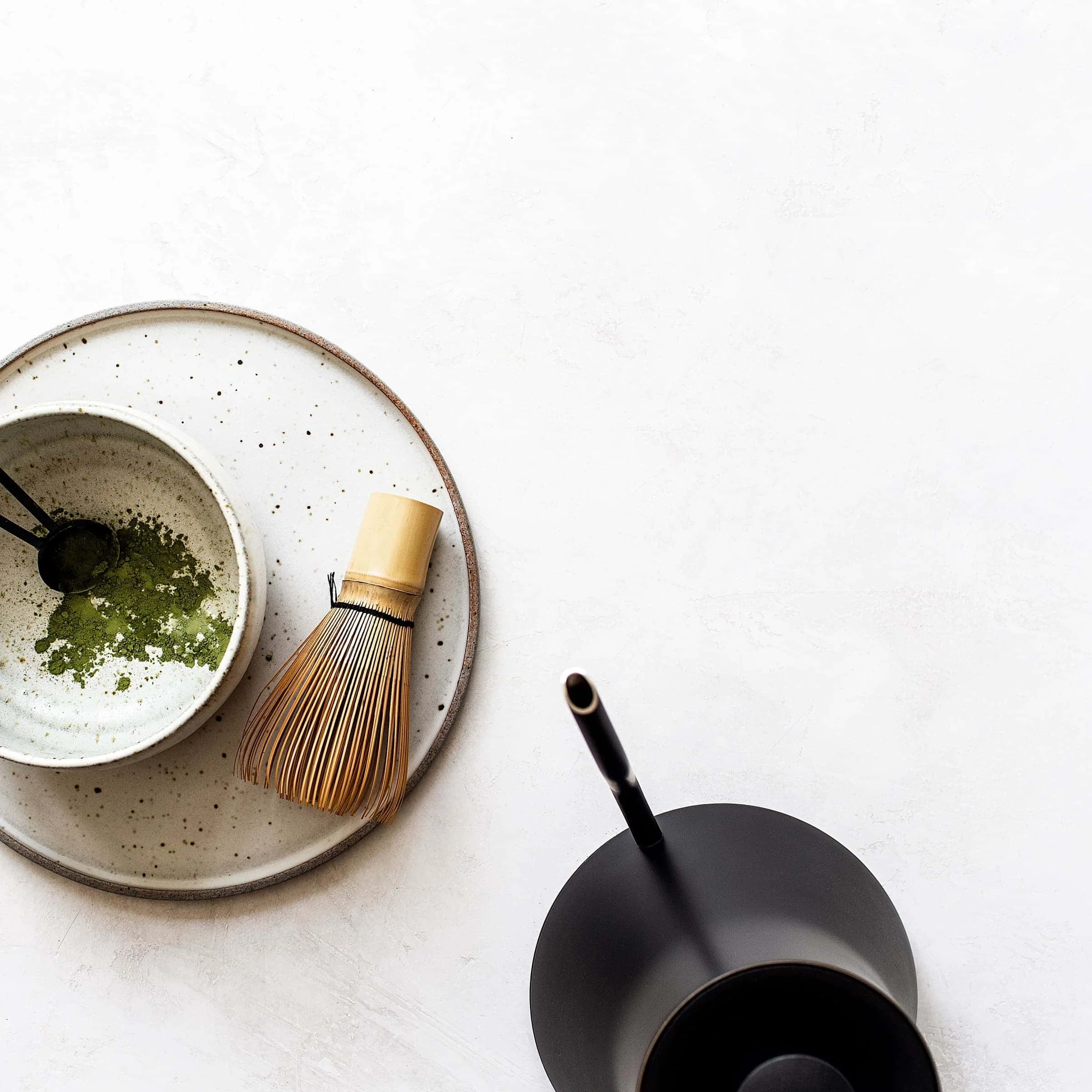 Zeit für Tee mit Matcha-Besen und Matcha und einer Wasserkanne