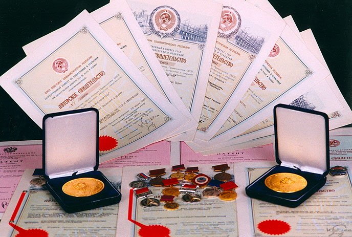 Various official documents, medals, coins, and certificates displayed on a surface.